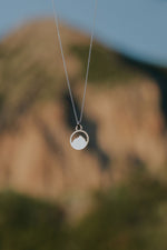Load image into Gallery viewer, Necklace with Mount Crested Butte pendant against a blurred natural background
