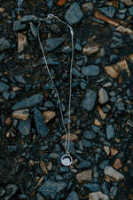 Load image into Gallery viewer, Silver Mount Crested Butte necklace with a pendant on a bed of small stones
